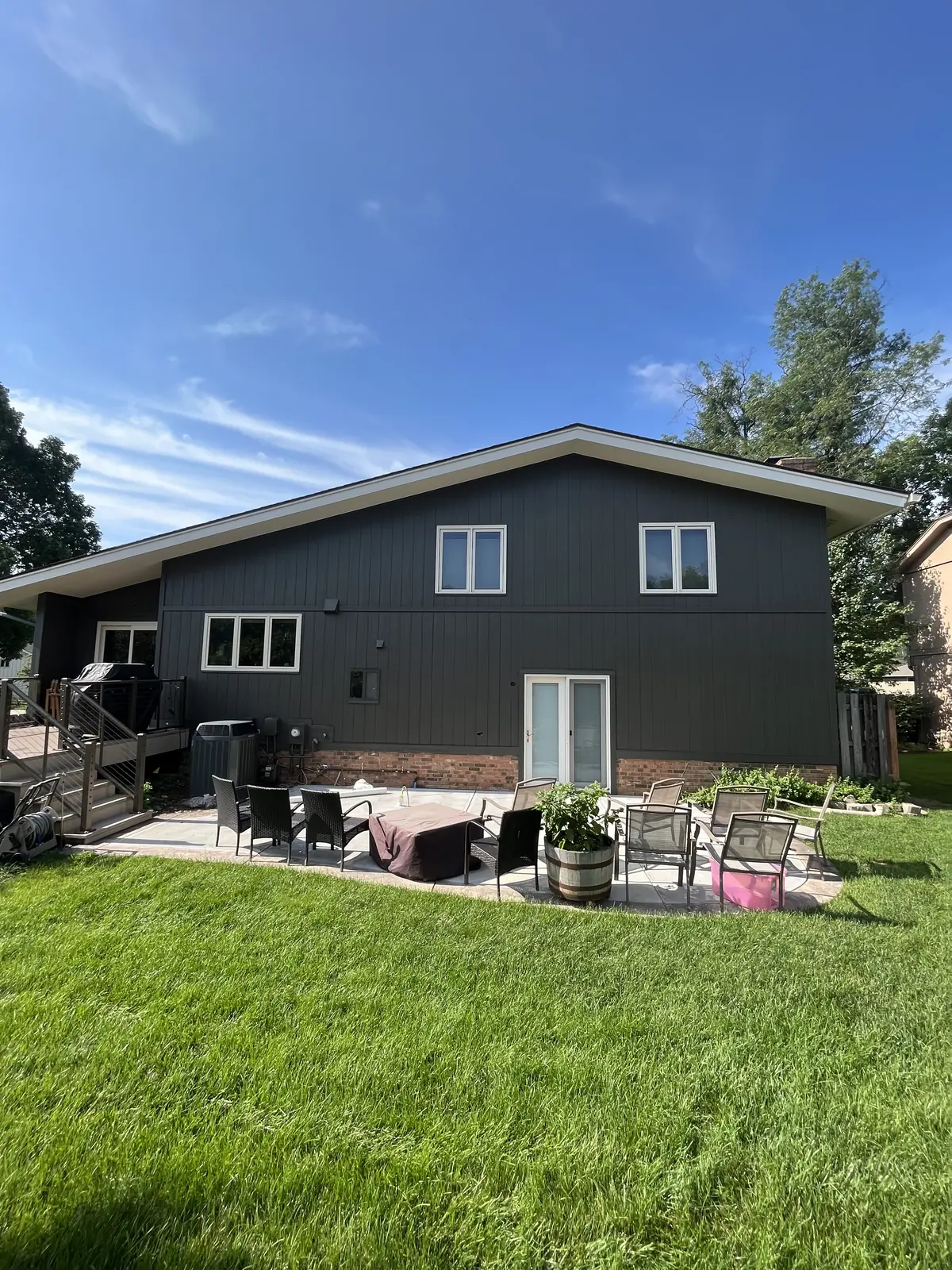 Completed dark siding across the rear elevation of a house