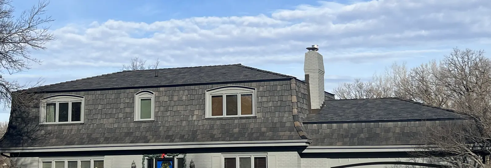 Finished shingle roof on a home photographed from the street