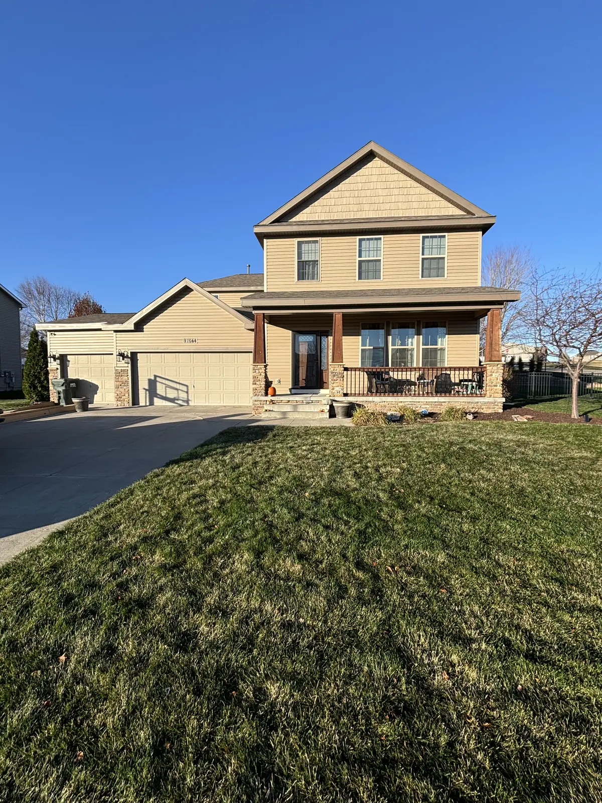 Finished two story home with the gutter run and downspout along the porch and garage eaves