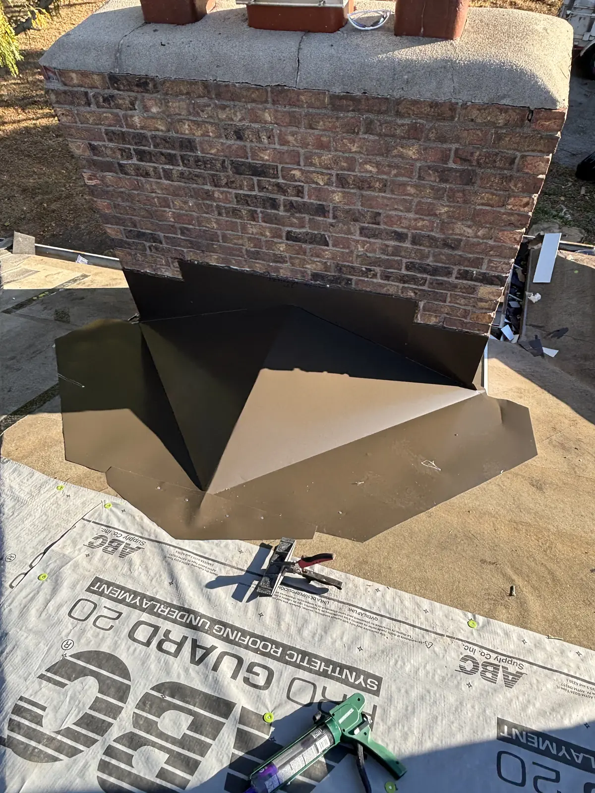 Newly installed metal flashing where the chimney meets the roof