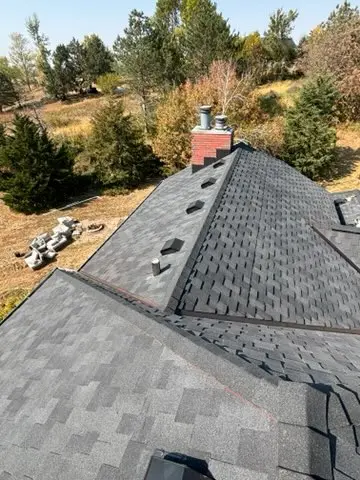 Finished hip and ridge caps running along a new shingle roof