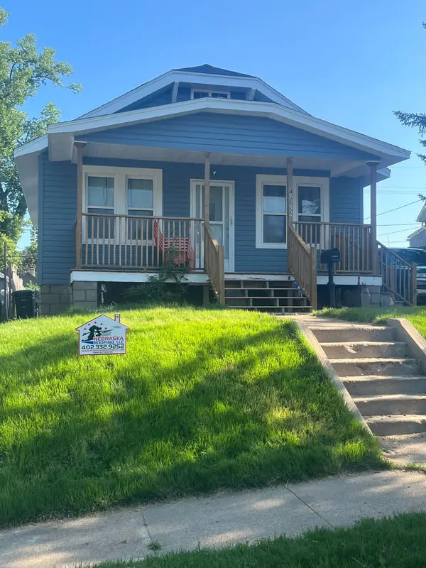 Bungalow with new blue lap siding, white window trim and a covered front porch